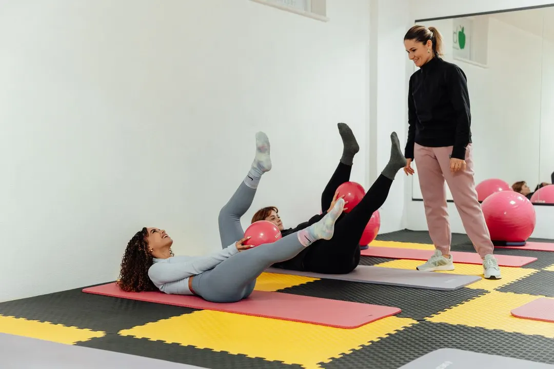 Cours de Pilates au sol avec ballons dans un studio